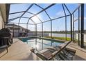 Enclosed pool area with lounge chairs offering relaxation and scenic lake views at 3478 74Th Avenue E Cir, Sarasota, FL 34243