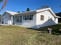 Exterior view of a white home with blue shutters and a flower pot with pink flowers at 3705 Chinaberry Rd, Bradenton, FL 34208