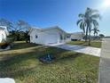 Single-story home with fresh white paint, a tidy lawn, and a freshly painted driveway on a bright day at 3705 Chinaberry Rd, Bradenton, FL 34208