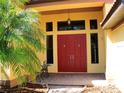Inviting entryway with double doors, transom windows, and an elegant seating area at 406 Petrel Trl, Bradenton, FL 34212