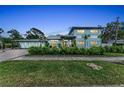 Charming two-story home with manicured landscaping, stone accents, and a paver driveway at 4153 Camino Real, Sarasota, FL 34231