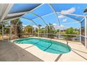Screened-in kidney shaped pool with views of canal, landscaping and blue skies at 4219 Eastlake Ct, Port Charlotte, FL 33948