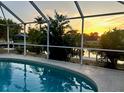 Screened-in pool at dusk, with tranquil water and view of the waterway at 4219 Eastlake Ct, Port Charlotte, FL 33948
