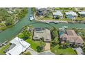 Gorgeous waterfront home with a private boat dock and a screened-in pool surrounded by lush landscaping at 452 Picasso Dr, Nokomis, FL 34275