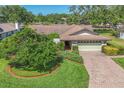 Well-kept front lawn with mature landscaping and a brick paver driveway at 4806 Huntleigh Dr, Sarasota, FL 34233