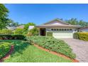 Home with mature landscaping and a brick paver driveway at 4806 Huntleigh Dr, Sarasota, FL 34233