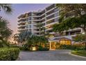 Elegant building exterior with lush landscaping and circular driveway at 535 Sanctuary Dr # A602, Longboat Key, FL 34228