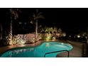 Inviting pool area at night with illuminated landscaping, creating a relaxing outdoor retreat at 606 Emerald Ln, Holmes Beach, FL 34217