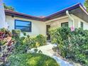 Close-up of the home's entrance with vibrant flowers and well-maintained shrubbery at 6102 Penny Ln, Bradenton, FL 34207