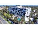 Stunning exterior of condo building features a pool, putting green, balconies, and well-maintained landscaping at 625 Beach Rd # 207, Sarasota, FL 34242
