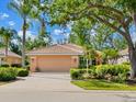 A well-maintained home featuring a two-car garage, manicured landscaping, and healthy shrubs adding to its curb appeal at 6748 Hickory Hammock Cir, Bradenton, FL 34202