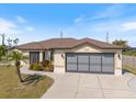 Well-maintained single-story home with a two-car garage and mature landscaping on a sunny day at 7145 Mamouth St, Englewood, FL 34224