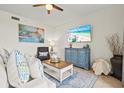 Well-lit living room featuring comfortable seating and a view of the beautiful beach on television at 7705 Grand Estuary Trl # 202, Bradenton, FL 34212