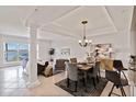 Open-concept living and dining area with elegant columns, neutral tones, and water view at 808 3Rd W Ave # 203, Bradenton, FL 34205