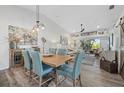 Open concept dining room with wood table and six upholstered chairs with views into the living room at 9550 High Gate Dr # 1526, Sarasota, FL 34238