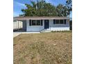 A front exterior view of the house with a nice lawn and awning at 1220 12Th W Ave, Palmetto, FL 34221
