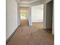 Bright hallway with large windows at the end, prepped for flooring installation at 19575 Fort King Run, Brooksville, FL 34601