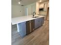 Kitchen island features white countertops, stainless steel dishwasher, and blue cabinetry at 19575 Fort King Run, Brooksville, FL 34601