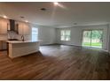Spacious open-concept living room featuring wood flooring, plenty of natural light and an eat-in kitchen at 19575 Fort King Run, Brooksville, FL 34601