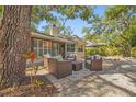 Cozy outdoor patio with comfortable seating, surrounded by lush landscaping and mature trees at 2072 Misty Sunrise Trl, Sarasota, FL 34240