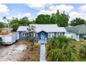Charming home featuring a new metal roof, a quaint blue door, and a well-maintained walkway leading to the entrance at 2120 8Th W Ave, Bradenton, FL 34205