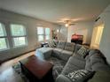 Comfortable living room with a gray sectional, hardwood floors, and natural light streaming through the windows, and ceiling fan at 2120 8Th W Ave, Bradenton, FL 34205