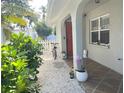 Charming front porch with plants, white gravel, and a red door, creating an inviting entrance at 240 Patterson Ave, Osprey, FL 34229