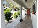 Inviting covered porch with tiled flooring, decorative plants, and a bright orange front door, offering a warm welcome at 240 Patterson Ave, Osprey, FL 34229