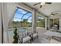 A screened patio with comfortable seating overlooks the pool and tranquil water view, perfect for relaxing and entertaining at 2818 Starwood Ct, Lakewood Ranch, FL 34211