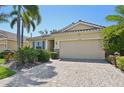 Well-manicured single Gathering home featuring a clay tile roof, brick driveway, and tropical landscaping at 3018 Oriole Dr, Sarasota, FL 34243