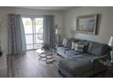 Cozy living room with plush sofa, glass coffee table, and view of the outdoor balcony with seating at 3368 Lake Bayshore Dr # 217 Building P, Bradenton, FL 34205