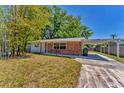 Quaint brick home with a covered carport and mature landscaping at 3545 Lalani Blvd, Sarasota, FL 34232