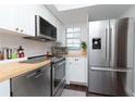 Bright kitchen with stainless steel appliances, subway tile backsplash, and butcher block countertops at 3810 N Oak Dr # N61, Tampa, FL 33611