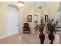 Inviting foyer with a chair, decorative mirror, and tile flooring at 4173 Westbourne Cir, Sarasota, FL 34238