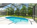 Screened-in pool area with a serene view of the green backyard at 4325 Renwick Dr, Parrish, FL 34219
