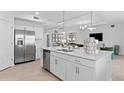 Modern kitchen with stainless steel appliances, a large center island, and sleek white cabinetry at 5616 Summit Pointe Cir # 101, Bradenton, FL 34210