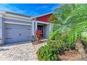 Inviting home entrance with well-kept landscaping and a brick paver walkway leading to the front door at 5811 Campina Pl, Palmetto, FL 34221