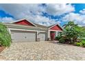 Charming exterior featuring a brick paver driveway and a three-car garage at 5811 Campina Pl, Palmetto, FL 34221