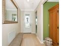 Inviting foyer featuring light wood floors, decorative glass door, and a seating bench at 5952 Snowy Egret Dr, Sarasota, FL 34238
