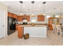 Open kitchen concept featuring granite countertops, island, black appliances, and casual dining at 5952 Snowy Egret Dr, Sarasota, FL 34238