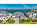 Stunning water view from this home with lush landscaping, hardscaped drive, and grey tiled roof at 600 Blue Shell Loop, Sarasota, FL 34240