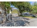 View of the house and long driveway with pavers and a stone mailbox on a sunny day at 6015 S Elkins Ave, Tampa, FL 33611