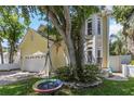 View of the house with a tree and swing set in the front yard at 6015 S Elkins Ave, Tampa, FL 33611