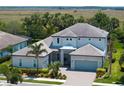 Elegant two-story home with a well-manicured lawn and lush landscaping, complete with a driveway leading to a two-car garage at 6317 Rivo Lakes Blvd, Sarasota, FL 34241