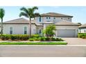 Charming two-story home features a well-kept lawn, mature landscaping, and a convenient two-car garage at 6317 Rivo Lakes Blvd, Sarasota, FL 34241