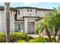 Inviting entrance highlighted by tropical landscaping, with a charming front porch and classic architectural details at 6317 Rivo Lakes Blvd, Sarasota, FL 34241