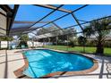 Inviting screened-in pool area with sparkling water, surrounded by lush greenery and a seating area for relaxation at 7301 12Th W Ave, Bradenton, FL 34209