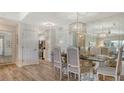 Open concept dining area with a glass table, view of the kitchen, and light wood flooring at 750 N Tamiami Trl # 304, Sarasota, FL 34236
