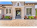 Inviting front entrance with a beautiful stone walkway, lush landscaping, and a glimpse into the light-filled interior at 7643 Haddington Cv, Bradenton, FL 34202