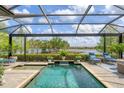 Relaxing screened-in pool area with comfortable lounge chairs and serene lake views, perfect for outdoor enjoyment at 7643 Haddington Cv, Bradenton, FL 34202